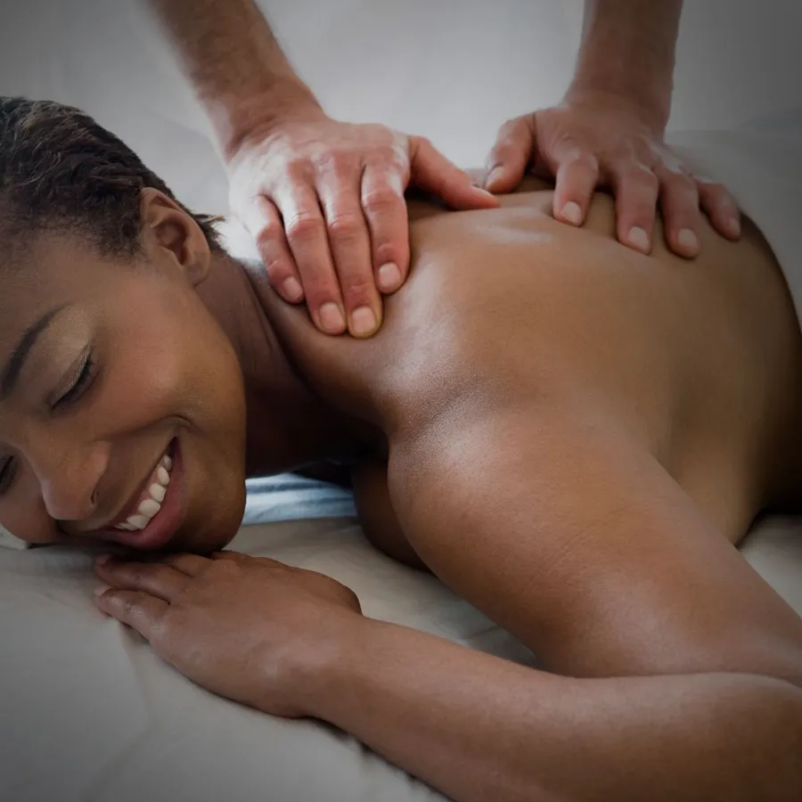 Therapist's hands working across a client's shoulders during a massage