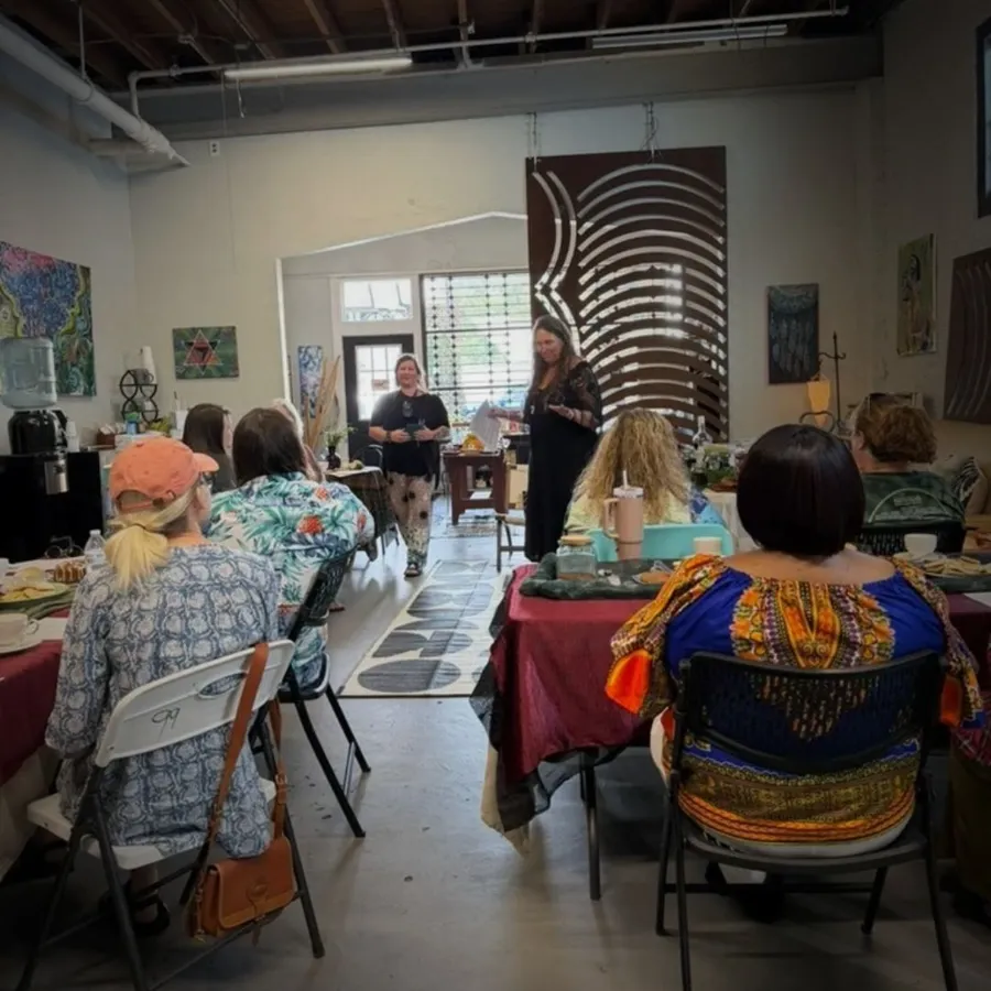 Guests seated at tables listening to hosts during a JaxZen gathering
